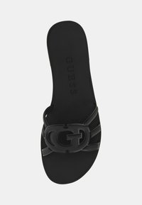 Must have mustekasd, millel on vormitud sisetald, lai rihm, millel on reljeefne "G" logo, ja sile kummist tekstuur. Minimalistlik disain.