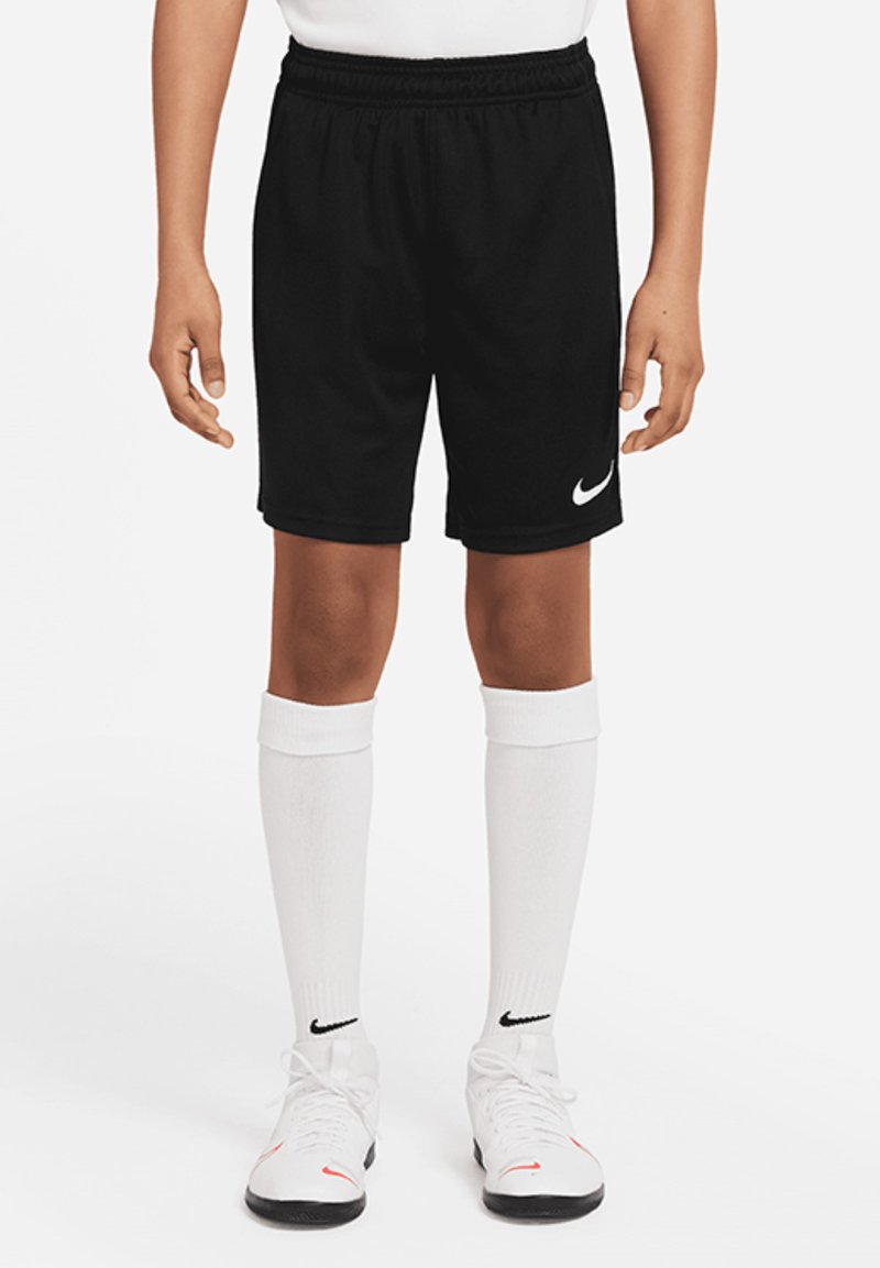 Schwarze Sportshorts mit einem elastischen Bund und einem weißen Nike-Logo. kombiniert mit weißen knielangen Socken und schwarzen Sportschuhen.