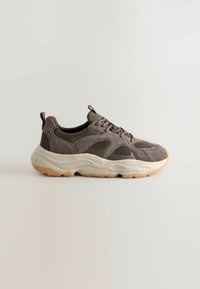 Gray suede and mesh sneaker with a thick beige sole, featuring a lace closure and pull tab at the heel for easy wear.