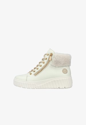 Sneaker montante en faux cuir crème avec fermetures éclair latérales, bord en fourrure pelucheuse et semelle blanche épaisse. Accents en métal doré sur les lacets et les fermetures éclair.