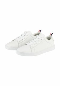 Witte leren sneakers met platte veters en een rubberen zool. Voorzien van een klein rood, wit en blauw label aan de hiel. Minimalistisch design.
