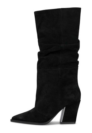 Bota negra de ante hasta mitad de la pantorrilla con caña caída, punta puntiaguda y tacón alto grueso y inclinado.