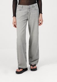 Light gray wide-leg jeans made of denim, featuring a classic five-pocket design and a subtle faded texture.