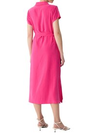Rosa, kurzärmliges Kleid mit Kragen, tailliert mit Gürtel und einem Midilängenrock. Glatte Textur mit einem leichten Glanz und seitlichen Schlitzen.