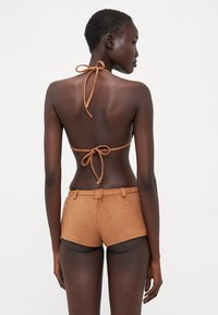 Set da bagno marrone composto da un top con collo all'americana con fiocco e pantaloni alti abbinati, realizzati in un morbido tessuto texturizzato.