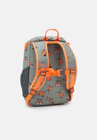 Sac à dos en tissu vert avec des bretelles et des accents orange. Présente des motifs de dessin animé ludiques avec des personnages souriants. Poche latérale en filet incluse.