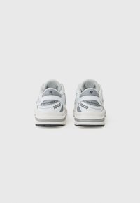 Baskets de sport blanches et grises avec des panneaux en maille, des languettes rembourrées et une semelle en caoutchouc. Présente le logo "new balance" et la mention "1000" sur les côtés.