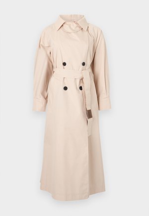 Μακρύ μπεζ καμπαρντίνα με διπλή σειρά μαύρων κουμπιών, ταιριαστή ζώνη, φαρδιά γιακά και μακριά μανίκια σε απλό φόντο.