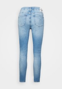 Ljusblå skinny jeans i denim, med bakfickor med sömnadsdetaljer och en liten etikett i midjan. Slät textur.