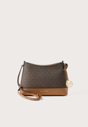 Bruine Michael Kors crossbodytas met logopatroon, tan leren afwerking, verstelbare riem en goudkleurige MK-bedel op een lichte achtergrond.