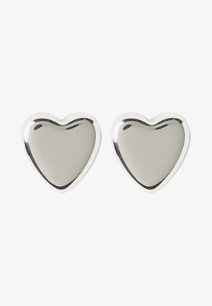 Deux objets métalliques en forme de cœur argentés brillants avec des surfaces lisses sur un fond blanc.