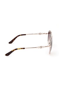 Gafas de sol de carey con brazos metálicos elegantes, enlaces detallados cerca de las patillas y lentes oscuros con degradado. Diseño elegante y moderno.