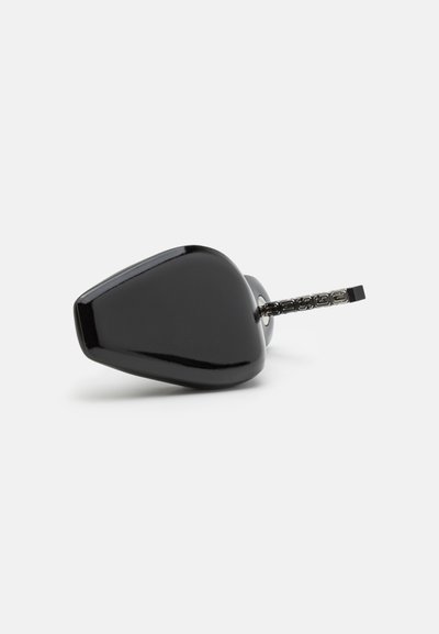 Objeto de cerámica negro con forma triangular, superficie brillante y un acento metálico texturizado que se extiende desde la base.