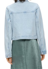Hellblaue Jeansjacke mit langen Ärmeln und einem verkürzten Schnitt. Merkmale sind klassische Nähte, Knopfdetails und ein gerader Saum.