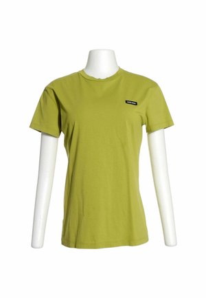 Maglietta verde a maniche corte su un torso di manichino bianco, con un piccolo logo rettangolare bianco e nero sul petto sinistro.