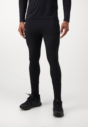 Black athletic leggings made of stretchy, moisture-wicking fabric. Features a fitted design and smooth texture. Worn with black running shoes.