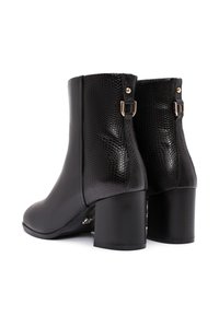 Botas negras hasta el tobillo con un brillo de textura de serpiente falsa, puntera redondeada y tacón cuadrado; cuentan con detalles de hebilla en la parte trasera.