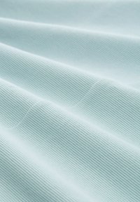 Hellblau geripptes Gewebe mit subtilen Wellenmustern, das eine glatte Textur und ein weiches Aussehen präsentiert. Eine Nahaufnahme betont die Details des Materials.