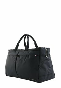 Schwarze Nylon-Reisetasche mit zwei Griffen, mit einem Reißverschluss oben und einer Seitentasche. Inklusive einem kleinen Markenlogo-Akzent in Farbe.