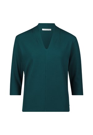 Maglia a costine in turchese con scollatura a V e maniche a tre quarti; presenta un taglio dritto e dettagli di cucitura discreti.
