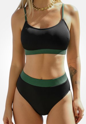 Zwarte geribbelde bikini top met groene accenten, voorzien van dunne bandjes. Hoge taille bikini broek in zwart met een groene geribbelde tailleband.