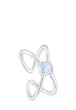 Anillo de plata con diseño de lazo entrelazado y una piedra preciosa azul facetada en el centro. Textura suave con un acabado pulido.