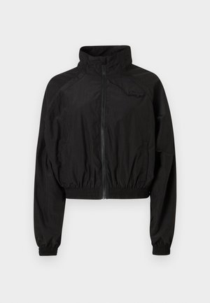 Melna īsā jakā, kas izgatavota no viegla auduma. Ierīcēm augsts apkakles, elastīgas piedurknes un rāvējslēdzēja priekšpuse. Diskrets logo akcents uz krūtīm.