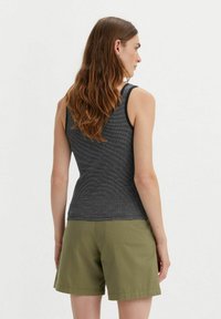 Gray tank top with thin straps, featuring a subtle striped texture, paired with olive green shorts, knee-length with a relaxed fit.
