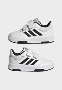 Białe sneakersy z czarnymi akcentami, z podeszwą na rzep, wykonane z gładkiej sztucznej skóry i gumowej podeszwy.