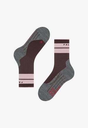 Paar knöchellange Socken in Braun und Grau mit rosa Streifen und rotem Text "FALKE W423 STABILIZING" auf der Sohle.