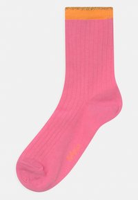 Meia rosa com ranhuras e punho com glitter laranja e dourado. Apresenta uma textura suave e forma de pé padrão. Logotipo impresso em amarelo.