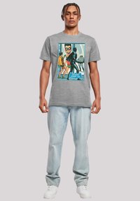 Gray cotton t-shirt featuring a graphic print with comic-style characters, framed in color, with the text "Distorted Dynamic Duo" at the bottom.