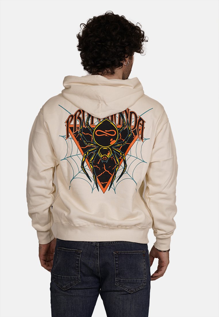 Felpa crema con una grafica di ragno su uno sfondo a forma di diamante in nero e arancione. Presenta un cappuccio con stringa e polsini a costine.