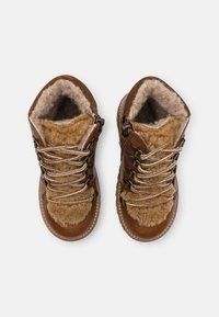 Botas de senderismo marrones con forro de lana, exterior de cuero y paneles texturizados marrones. Presentan ganchos de metal y cordones gruesos a rayas.