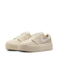 Kremfargede lavtopp sneakers med teksturert lær overdel, preget av perforeringer, og en kontrasterende hvit Nike swoosh. Gummisåle med riller.