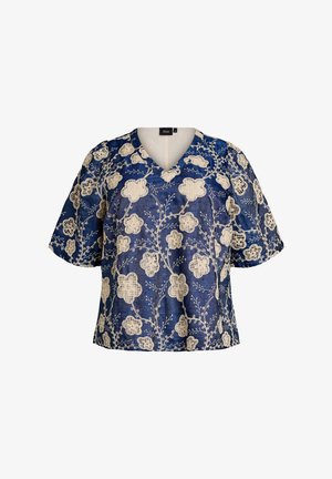 Modrá krátká halenka s krémovým květinovým krajkovým vzorem a výstřihem do V, zobrazena na bílém pozadí.