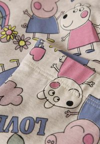 Bawełniana tkanina z kolorowym kreskówkowym wzorem postaci, kwiatów i chmur; odcienie różu, niebieskiego i kremowego z detalami szwów.