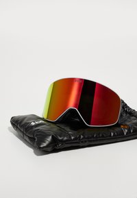 Ochelari de schi cu lentile roșii și verzi, cu un cadru alb elegant, așezați pe o husă neagră căptușită. Prezintă o suprafață moale și texturată.