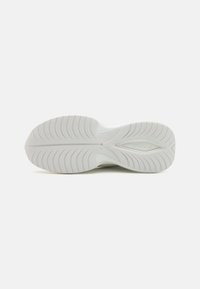 Sole di sneaker bianco con un motivo di grip in gomma testurizzata e logo del marchio incorporato, progettata per aderenza e durata.