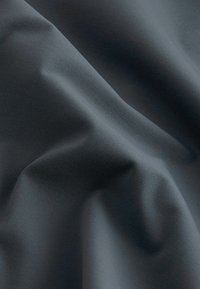 Dunkelgrauer Stoff mit einer glatten, leicht glänzenden Textur, der weiche Falten und ein gleichmäßiges Finish aufweist, geeignet für verschiedene Anwendungen.