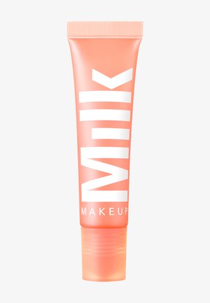 Perzikkleurige knijptube met een wit logo "MILK MAKEUP," met een matte afwerking en een transparante dop aan de onderkant.