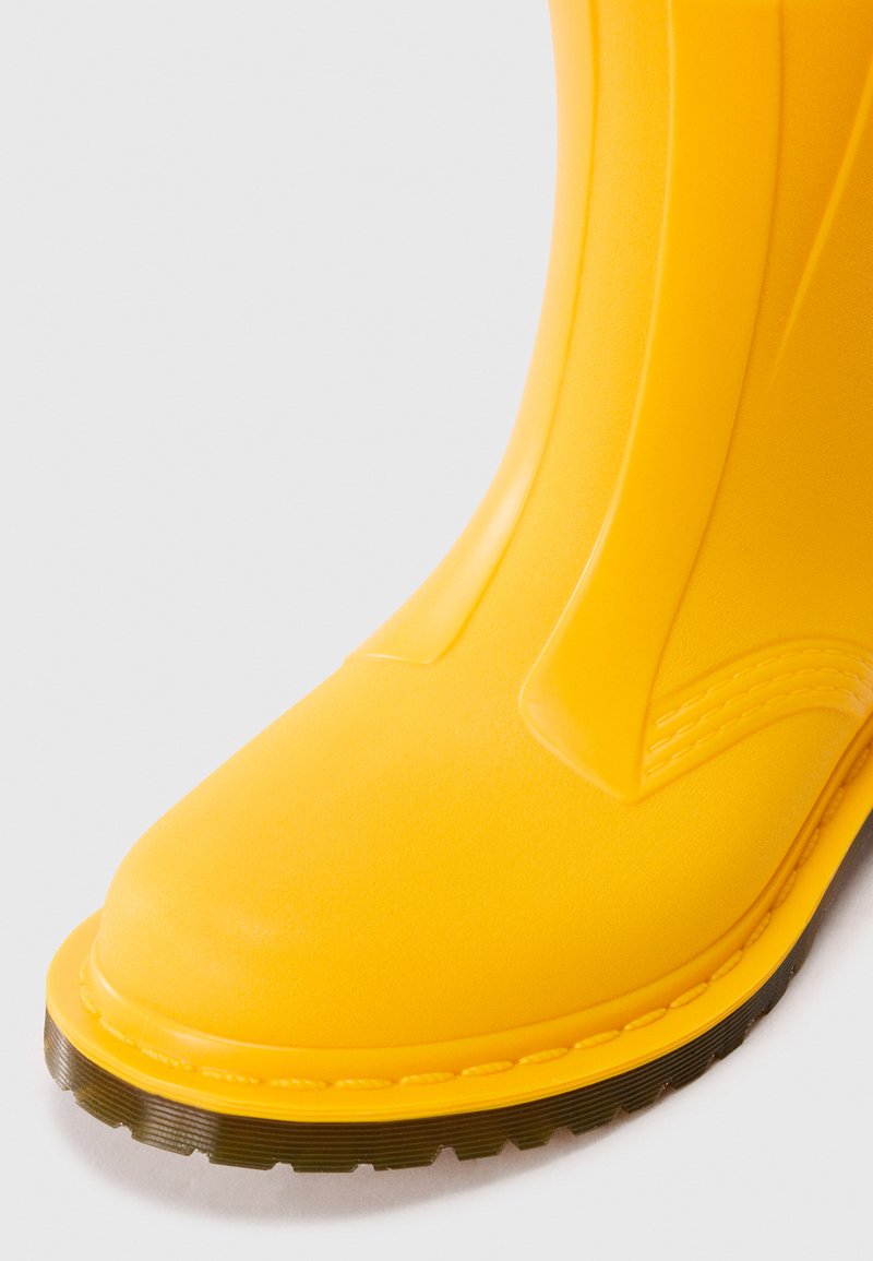 Yellow rubber boot with a rounded toe, smooth surface, and textured accents. The sole features a ridged design for grip.