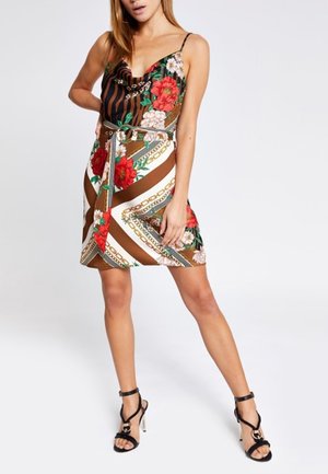 Robe à motifs floraux dans des teintes brunes, blanches et vertes, présentant une silhouette ajustée, des bretelles spaghetti et une ceinture assortie à la taille.