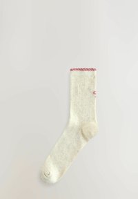 Crèmefärgad strumpa med ribbad mudd och rosa accent upptill. Mjuk textur, något melerad design, ankellängd.