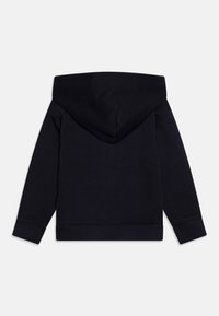 Felpa blu navy con una consistenza morbida in cotone. Presenta un grande cappuccio e polsini e orlo a costine. Il retro è semplice e privo di ulteriori dettagli.