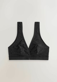 Sort blonder bralette med brede stropper, dyb V-hals og en sømløs bånd under brystet, lagt fladt på en lys overflade.