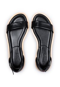 Schwarze Ledersandalen mit minimalistischem Design, ausgestattet mit zwei breiten Riemen, einer hellen Sohle und einer Knöchelschlaufe mit einem Reißverschlussdetail.