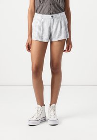 Pruhované šortky z látky s upraveným střihem, vybavené předním zapínáním na knoflík a bočními kapsami. Barva: světle šedá a bílá.