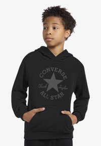 Hanorac negru dintr-un amestec de bumbac, cu o stea mare gri și textul "Converse Chuck Taylor All Star". Buzunare tip cangur în față.