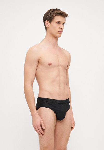 Caleçons de bain noir en matériau texturé, avec une large ceinture et un discret détail de logo à l'avant.